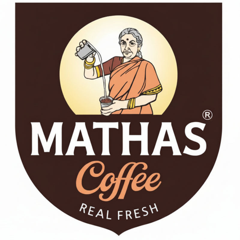 Mathas Coffee logo featuring an illustration of a woman in an orange sari pouring milk into a cup, set against a dark brown shield with white and orange text reading 'MATHAS Coffee REAL FRESH'.